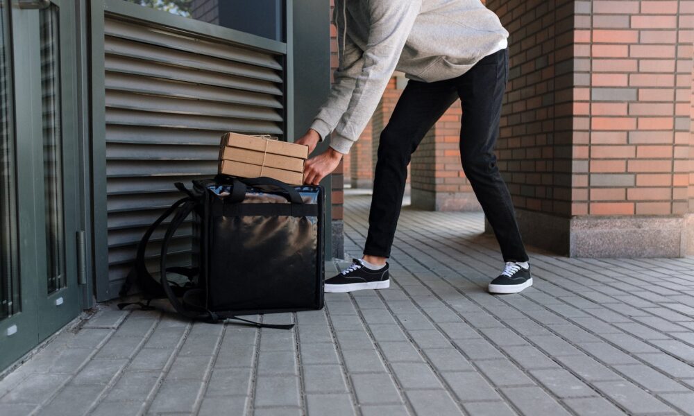 man in white dress shirt and blue denim jeans holding black luggage bag