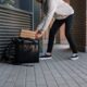 man in white dress shirt and blue denim jeans holding black luggage bag